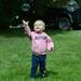 20-month-old Michigan fan Cammy Faust, Dearborn, reaches for a bubble as she plays in the grass while tailgating outside of Michigan Stadium before the Air Force game on Saturday. Melanie Maxwell I AnnArbor.com